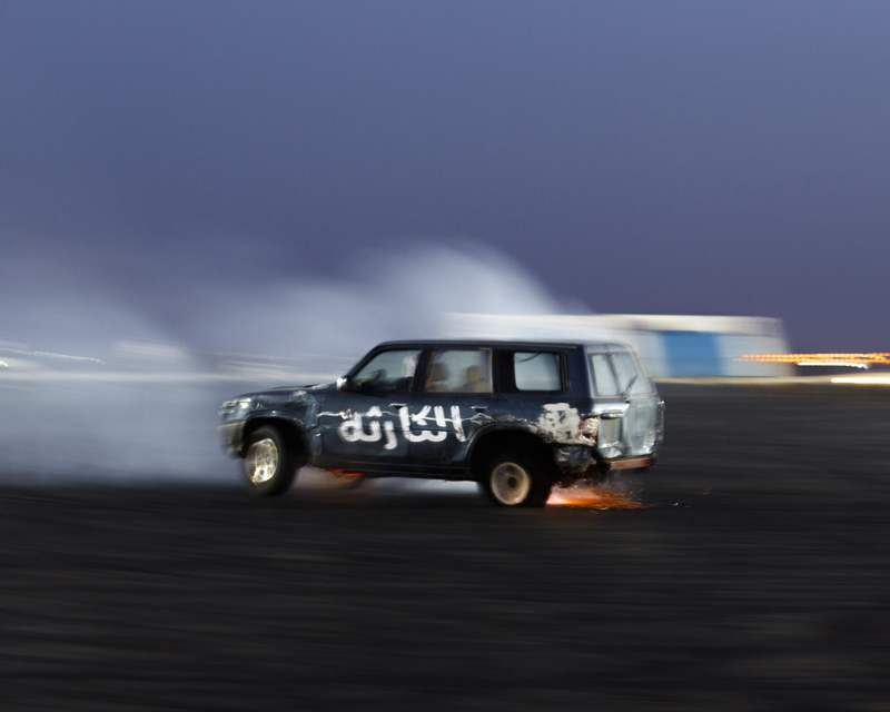 A member of the "Disaster" group burns his tire down to the metal rim sending sparks as it meets the pavement.