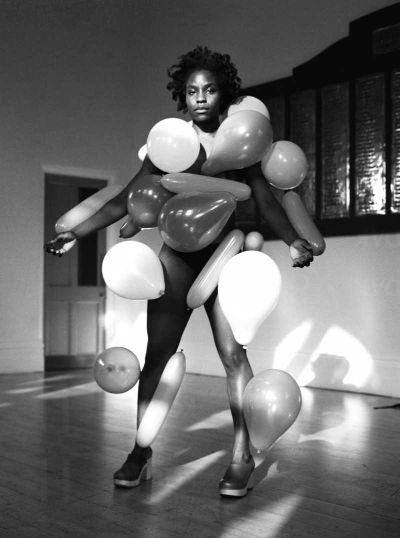A black and white photo of a nude woman coated in static-charged balloons.
