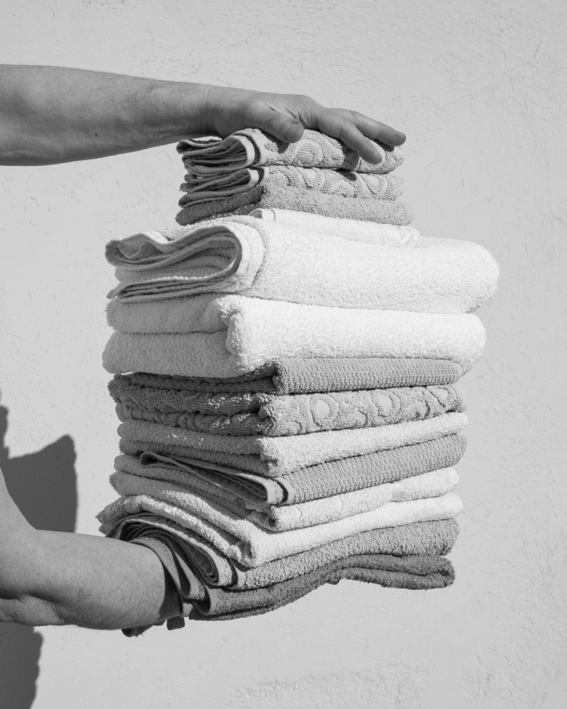 Two hands hold a pile of towels.