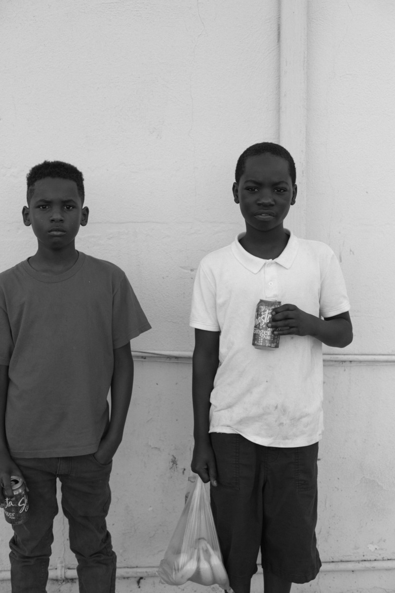 Two young black boys stand and face the camera confidently.