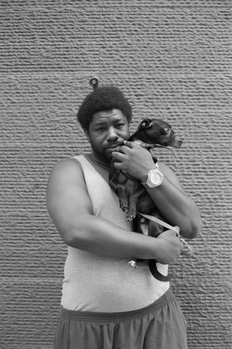 A man holds his dog lovingly in his arms.