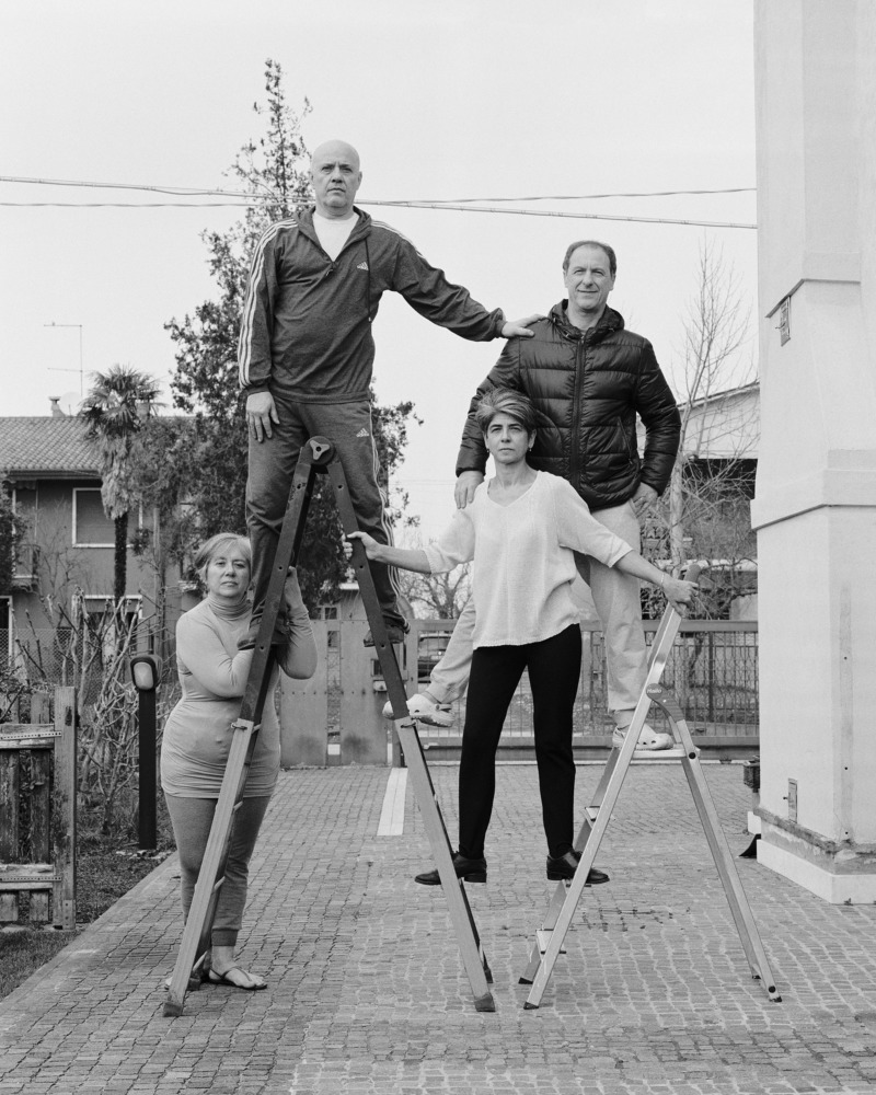 The Agostini family climb a set of ladders.