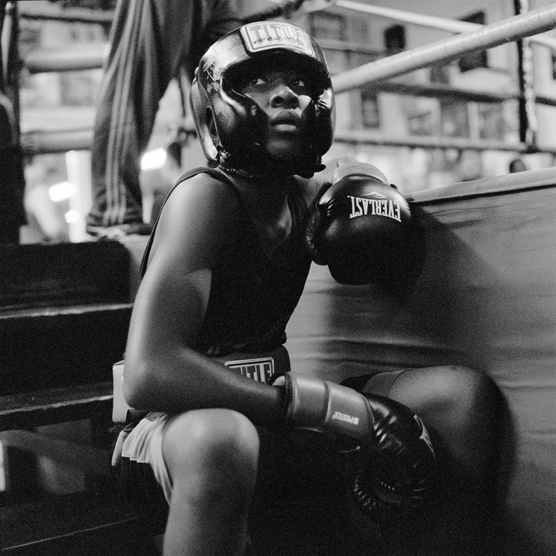 A moody photograph of a young boxer captured in striking black and white.