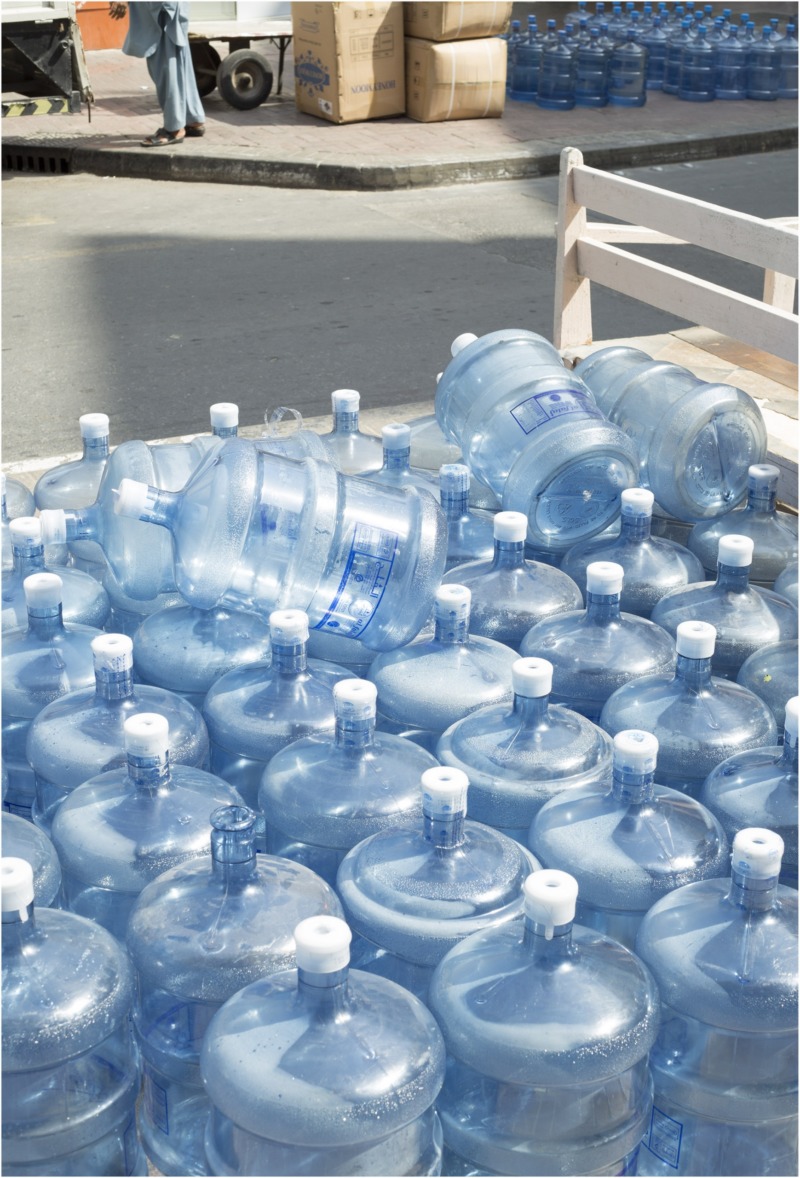 A pile of dozens of empty water bottles, ready to be refilled.