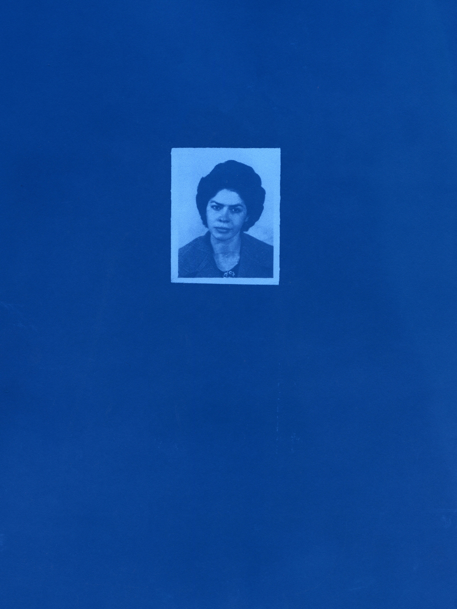 A cyanotype of an old passport photograph of a woman.